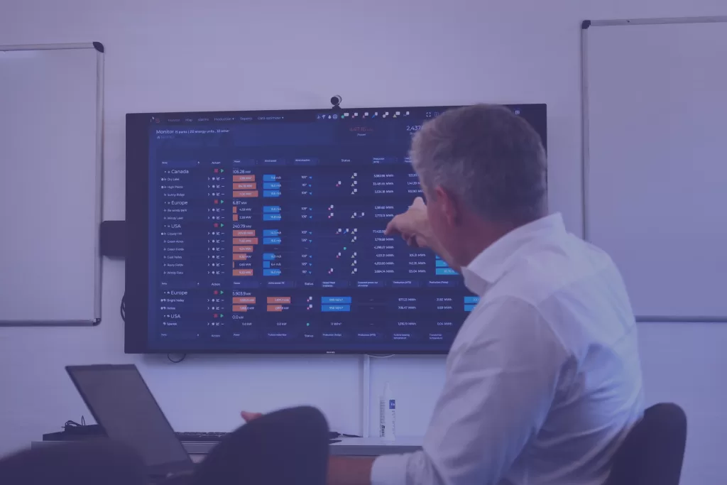 Person reviewing data dashboard on a BESS monitoring platform display - purple background